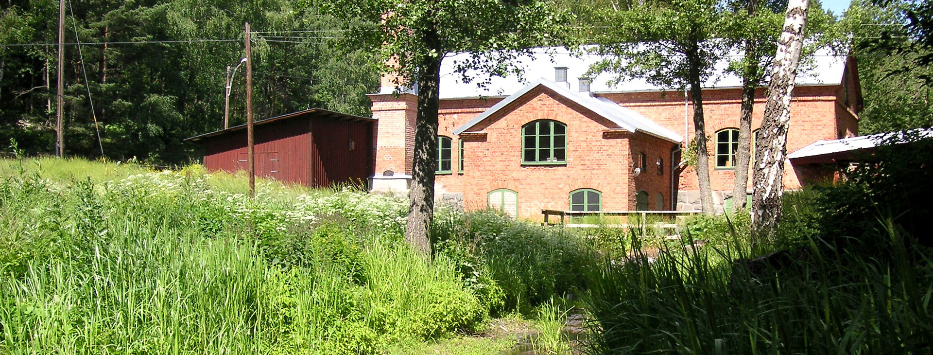 Ett tegelhus som syns genom träden.