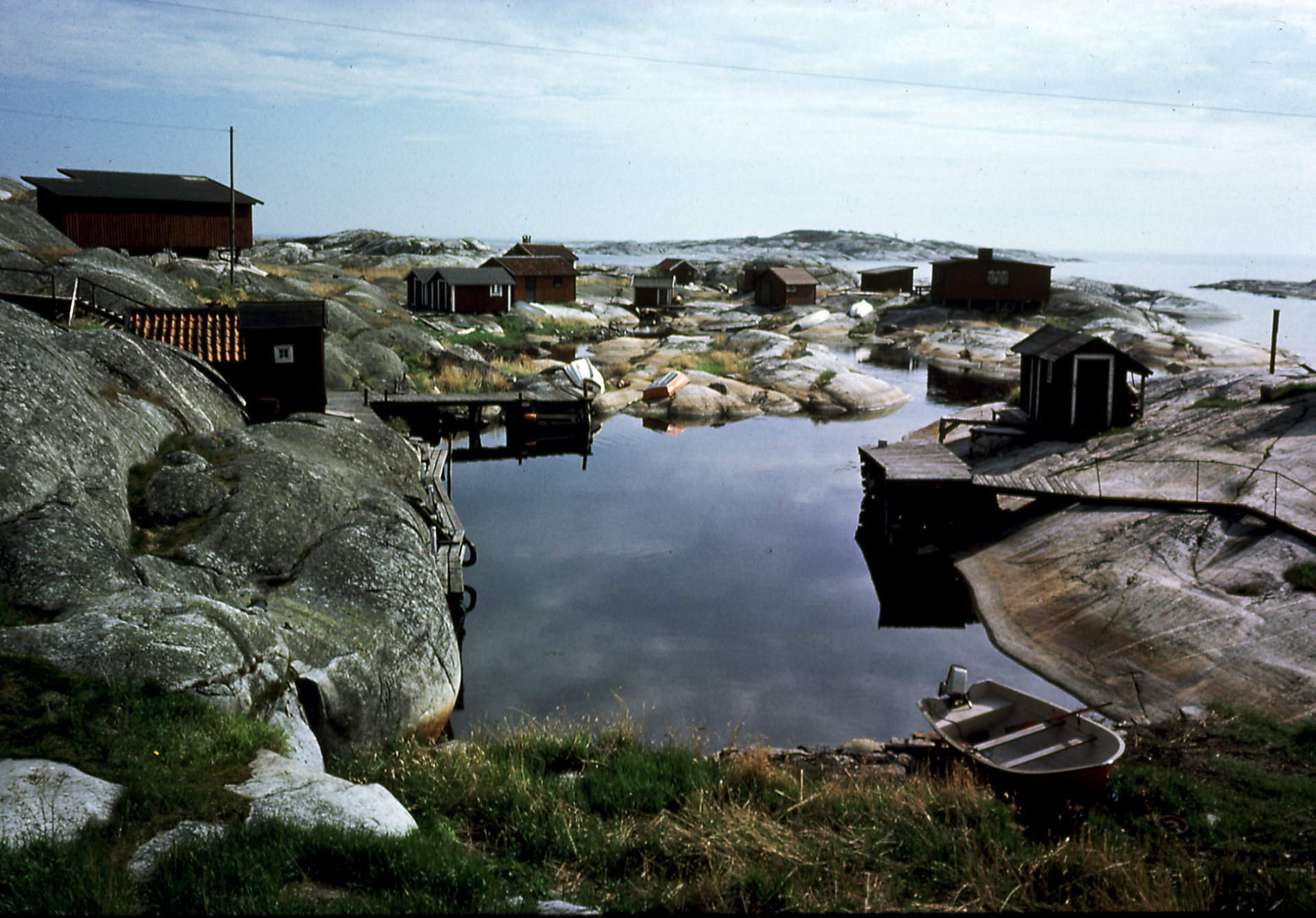 Klippor som små hus står på. Klipporna ligger intill vattnet.