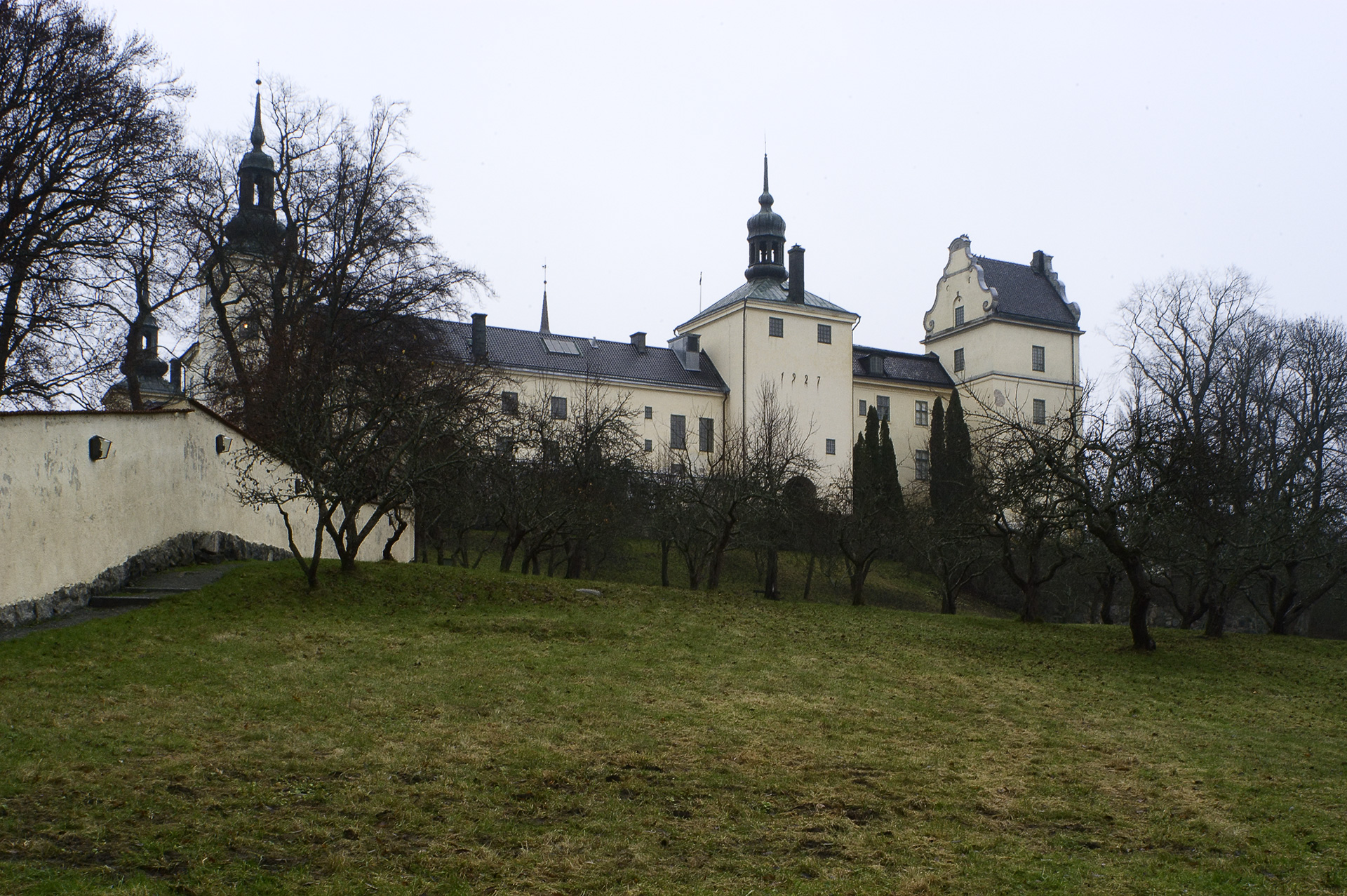 Ett stort, vitt hus står på en höjd.