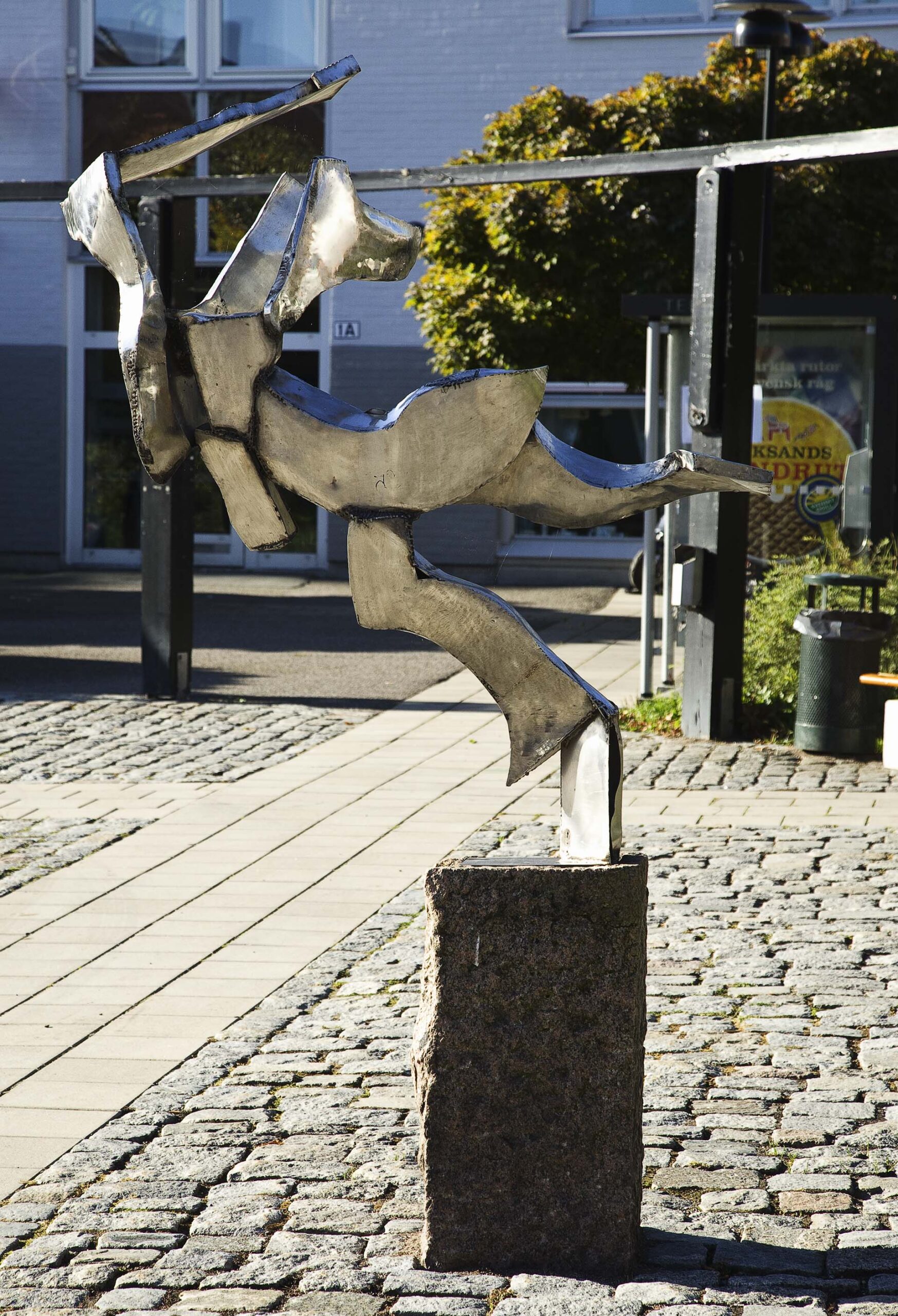En glänsande skulptur i torgmiljö.