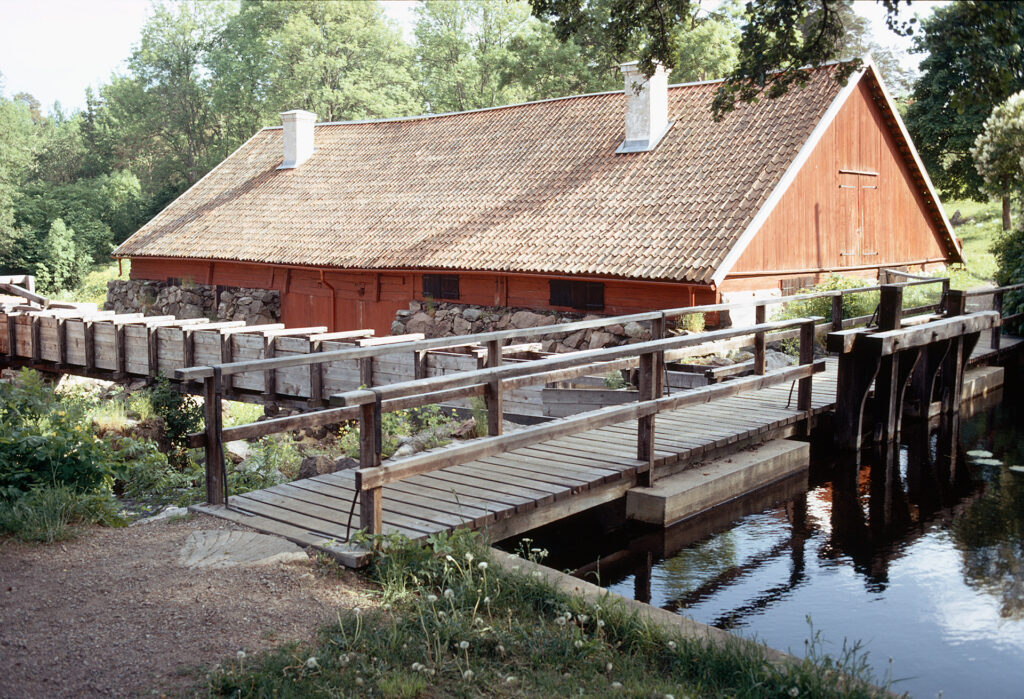 Ett trähus som ligger vid en träbro.