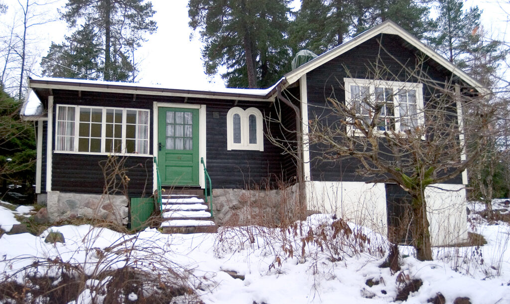 Ett trähus står i snön.