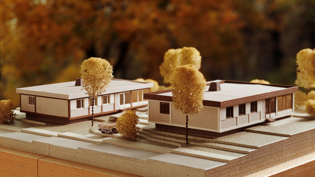 Ett litet bygge som visar två hus och ett par träd.