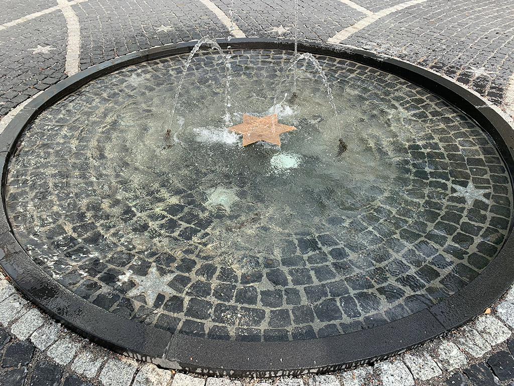 Porlande fontän med stjärna av mässing i mitten.