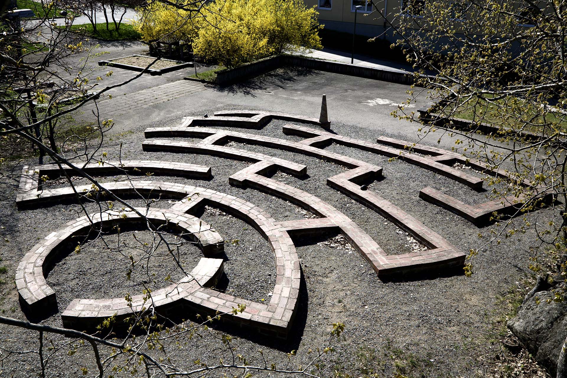 Låg mur av tegel som bildar gångar att gå i sedd uppifrån.