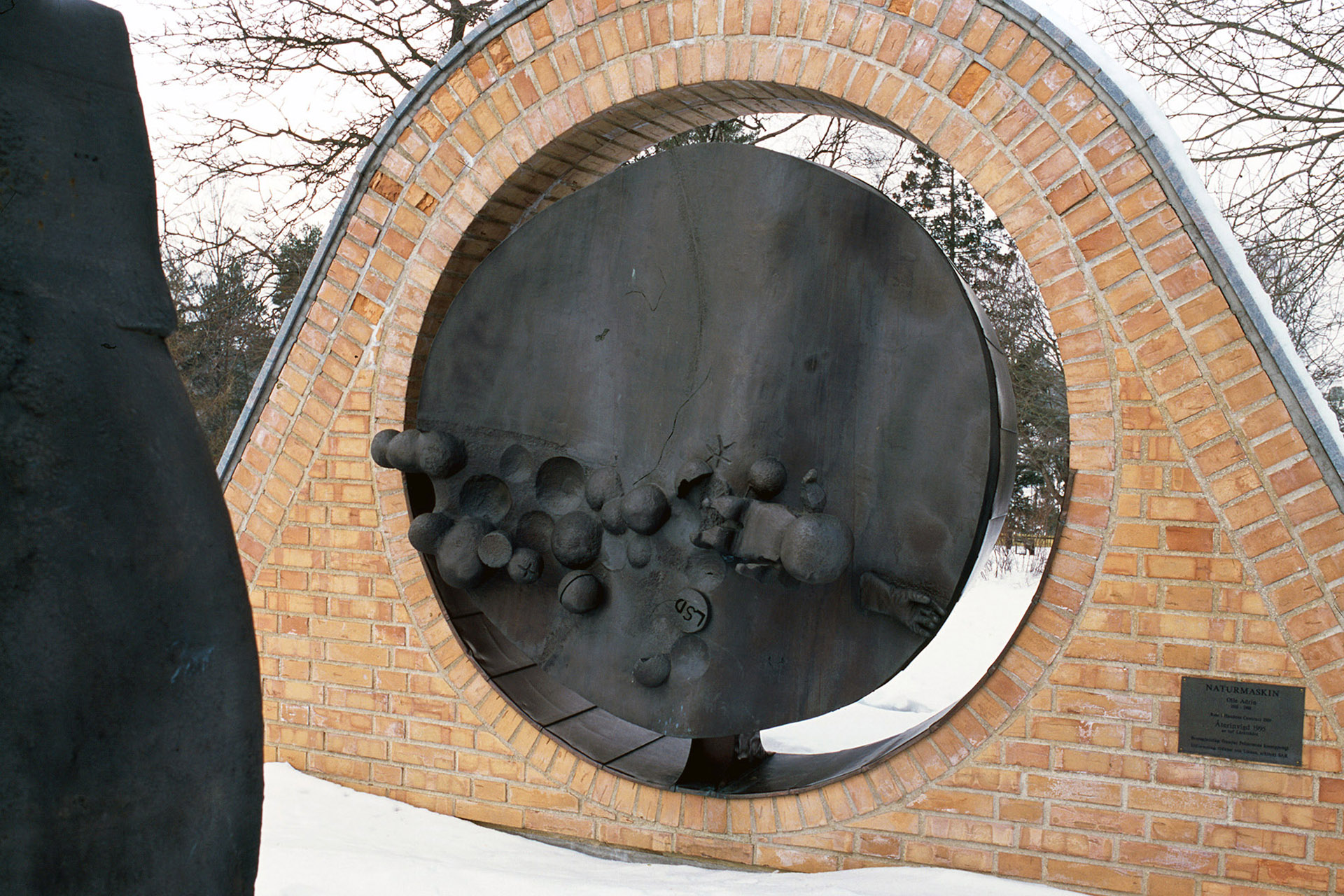 En böjd tegelkonstruktion med en rund svart brons inuti.