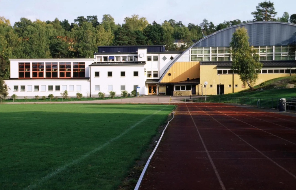 Utsidan av en sporthall med en sprintbana som leder fram till byggnaden.