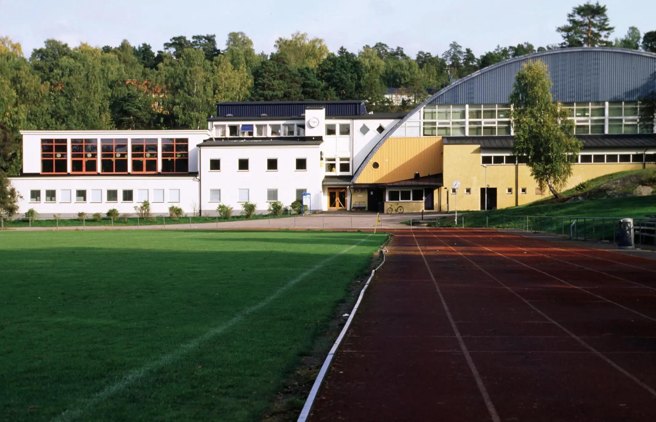 Utsidan av en sporthall med en sprintbana som leder fram till byggnaden.