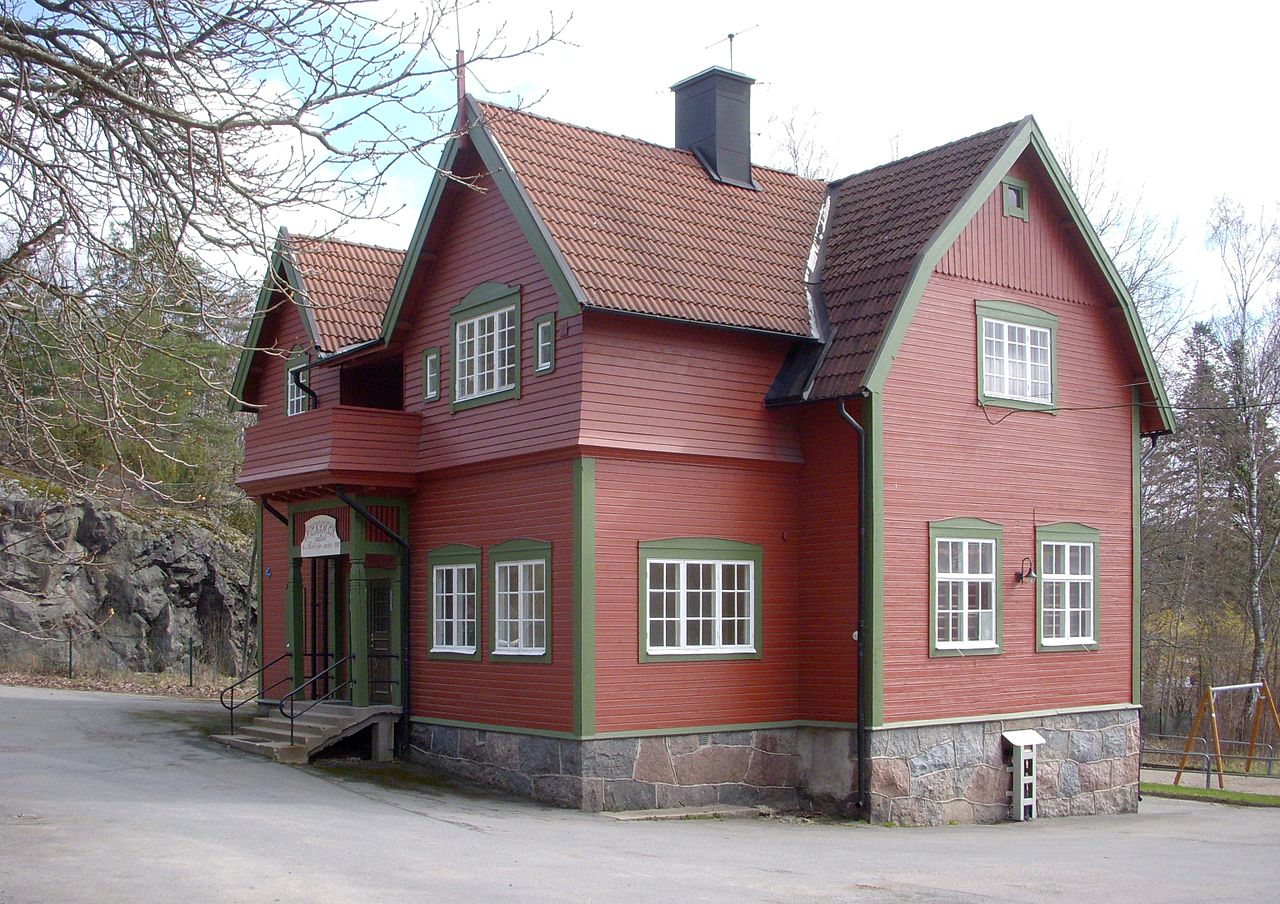 Färgfoto av den röda träskolan i två våningar.