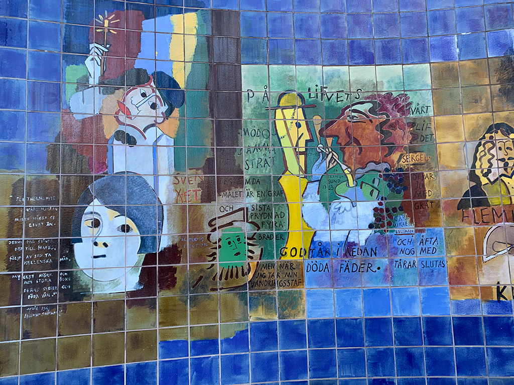 Blåa kakelplattor med målningar av människor gjorda i olika färger.