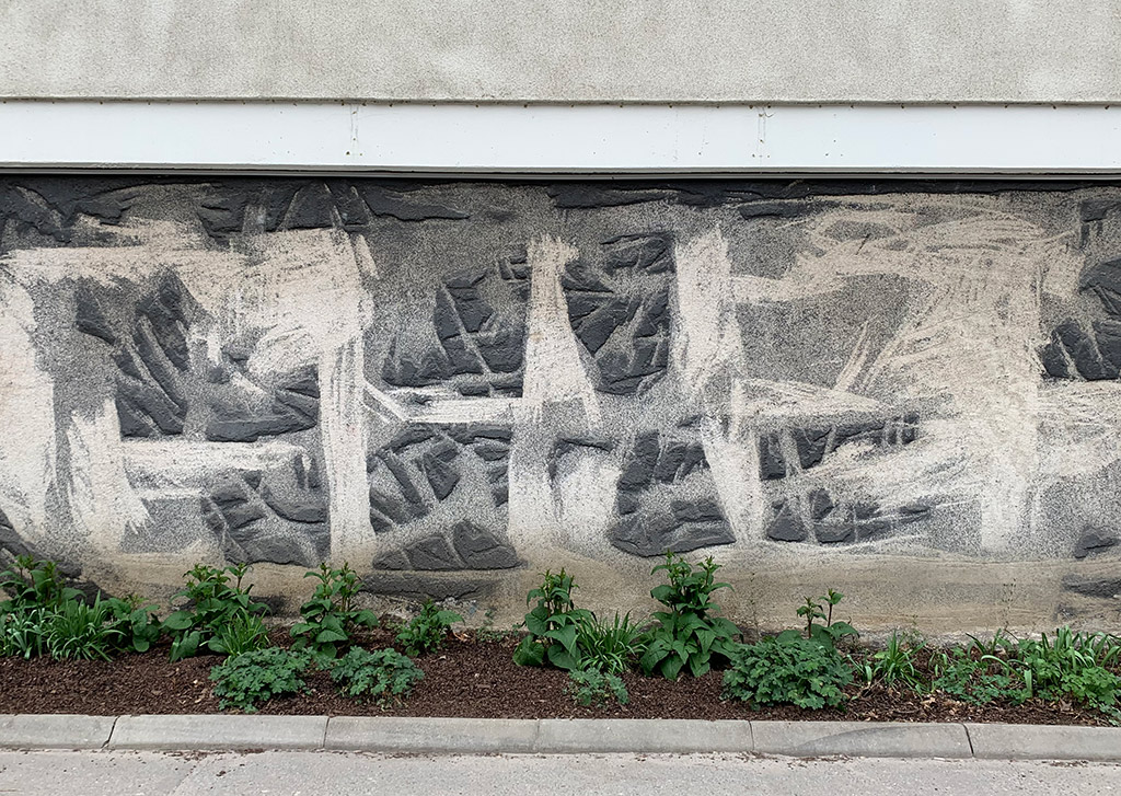 Abstrakt konstverk i betong. Gjort som ristningar i svart och vitt.