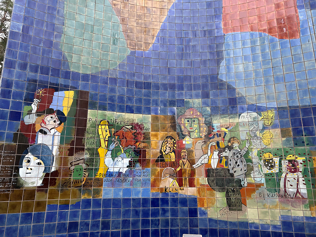 Blåa kakelplattor med målningar av människor gjorda i olika färger.