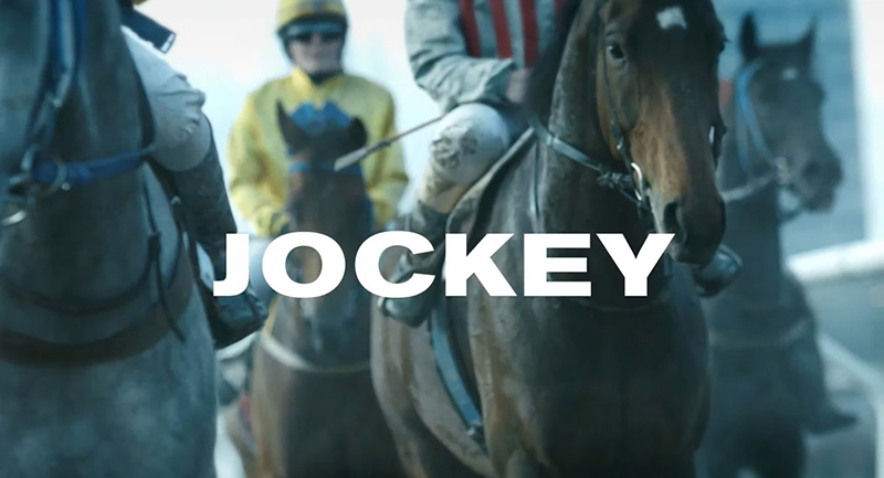 En bild på två jockeys till häst. Över bilden står texten Jockey.