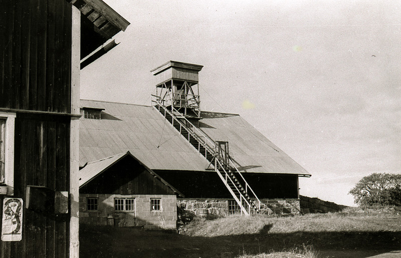 En trappa leder upp till ett torn som höjer sig över ladugårdstaket.
