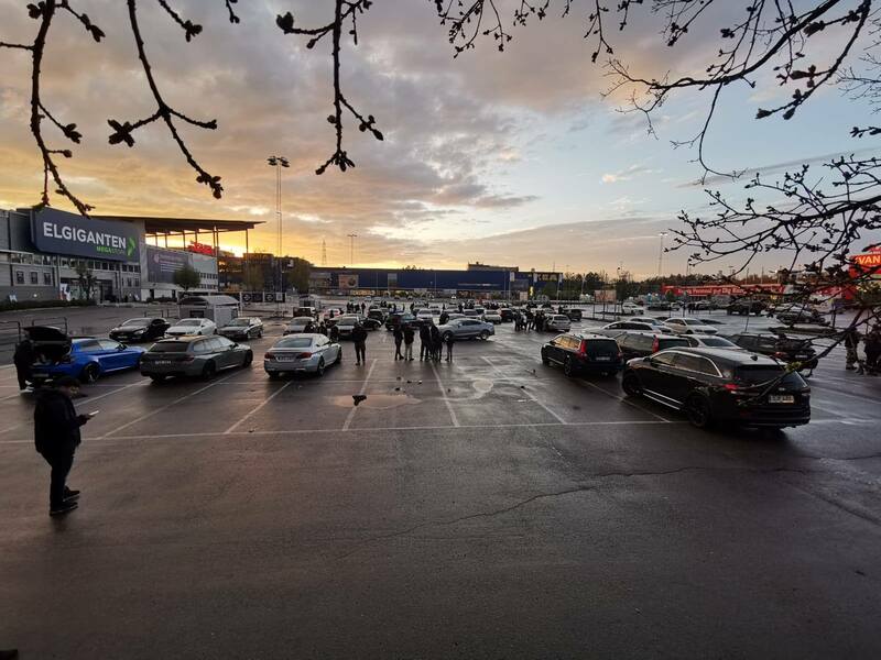 Bilar och människor på parkering.