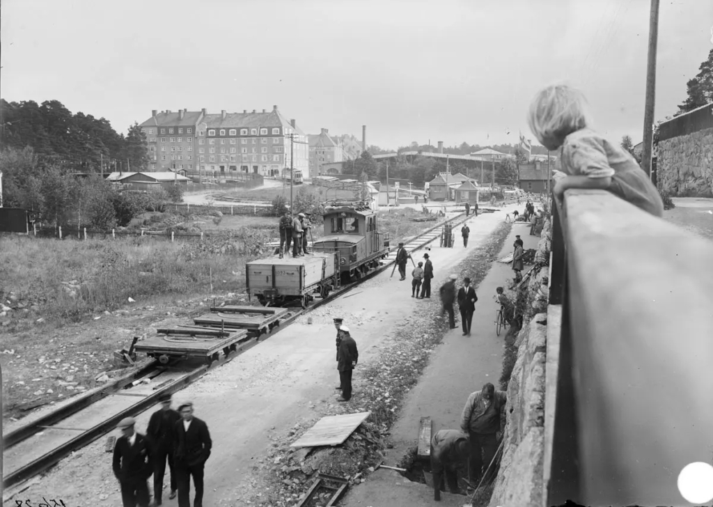 Nyfikna människor kollar in bygget av järnväg i Sundbyberg.